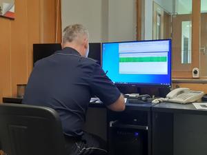 Policjant pracujący przy komputerze.