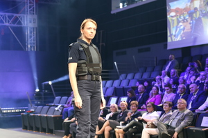 policjantka na wybiegu prezentuje mundur podczas pokazu mody służb mundurowych.