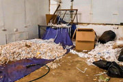 Nielegalna fabryka z tytoniem, w pomieszczeniu porozrzucane papierosy.