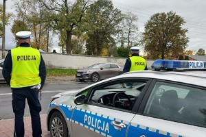 Policjanci przy radiowozie w trakcie kontroli.