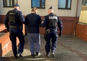 policjanci prowadzą zatrzymanego