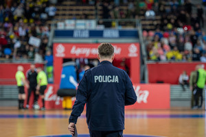 Policjant tyłem na boisku.