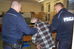 policjanci prowadzą zatrzymanego