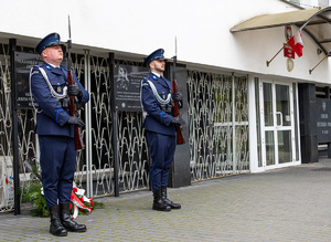 Policjanci przy tablicy upamiętniającej ofiary Zbrodni Katyńskiej.