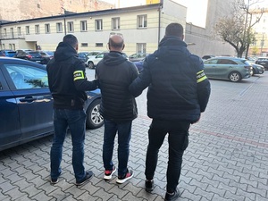 Policjanci prowadzą zatrzymanego.