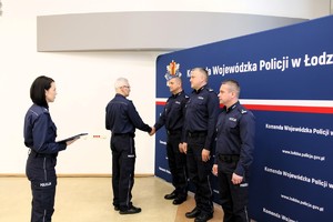 Komendant Wojewódzki Policji w Łodzi wręcza rozkaz awansowanym policjantom.