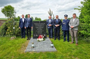 Komendant Wojewódzki Policji w Łodzi wraz z samorządowcami stoją obok pomnika.
