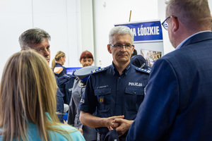 Komendant Wojewódzki Policji w Łodzi rozmawia z gośćmi podczas targów.