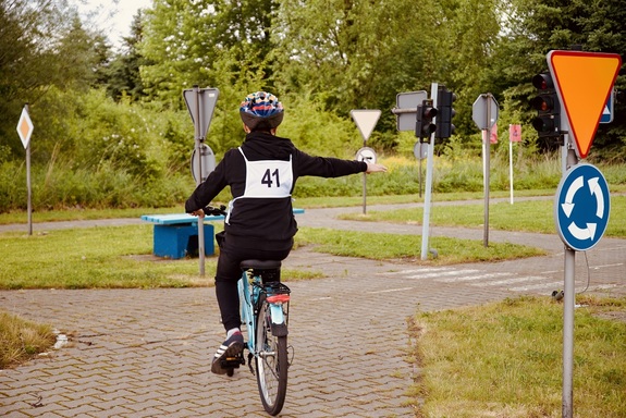 Uczeń jedzie na rowerze po torze przeszkód.