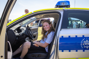 dziewczynka w policyjnym radiowozie podczas pikniku z okazji Dnia Dziecka.