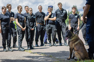 uczniowie klasy policyjnej podczas  pokazu tresury policyjnego psa służbowego.