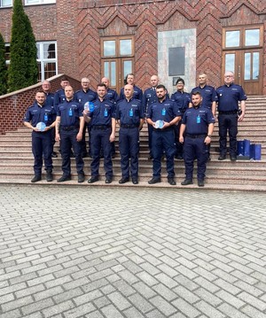 Na zdjęciu zwycięzcy zawodów ratowników policyjnych stoją przed budynkiem Szkoły Policji w Słupsku.