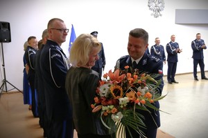 insp. Tomasz Jędrzejowski wręcza kwiaty swojej żonie.