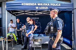 stoisko policyjne wystawione podczas wydarzenia , a przy nim policjanci i odwiedzający.