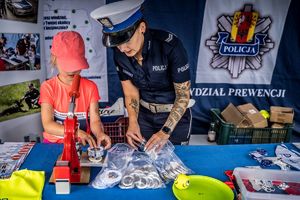 stoisko policyjne wystawione podczas wydarzenia , a przy nim policjanci i odwiedzający.