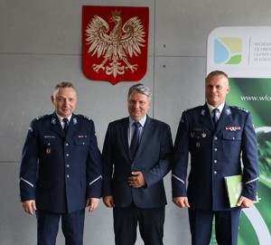 Komendanci z Komendy Wojewódzkiej Policji w Łodzi i prezes Zarządu Wojewódzkiego Funduszu Ochrony Środowiska i Gospodarki Wodnej stoją na tle godła.