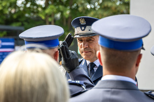 Zastępca Komendanta Głównego Policji oddaje honor, policjant oddaje honor, widać z tyłu czapki policjantów.