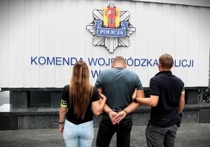 Policjanci trzymają zatrzymanego.