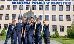 na zdjęciu policjanci stoją przed budynkiem Akademii Policji w Szczytnie.