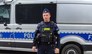 Policjant przy radiowozie.