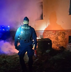 Policjant w trakcie gaszenia pożaru.