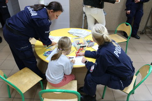 Policjant z dziećmi w trakcie pikniku.