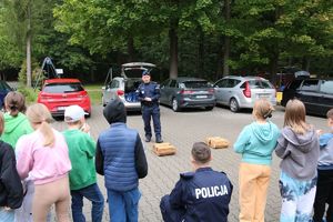 Policjant z psem służbowym i dziećmi w trakcie pikniku.