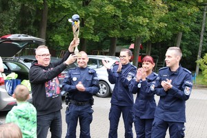 Policjanci z dziećmi w trakcie wręczania nagród za konkursy.