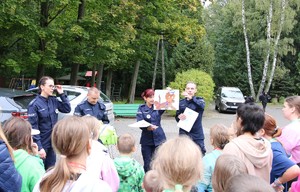 Policjanci z dziećmi w trakcie wręczania nagród za konkursy.