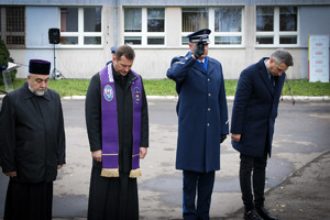 Oficjele składają hołd przed pamiątkową tablicą.