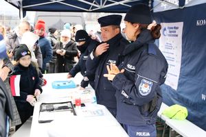 Policjanci podczas pikniku pod namiotem rozmawiają z mieszkańcami.