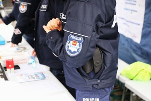Policjanci podczas pikniku pod namiotem rozmawiają z mieszkańcami.