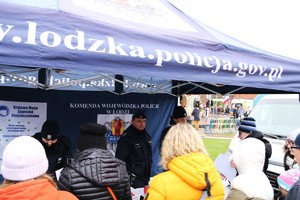 Policjanci podczas pikniku pod namiotem rozmawiają z mieszkańcami.
