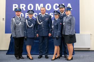 Sześcioro policjantów stoi na ściance w galowych mundurach.