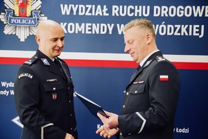 I Zastępca Komendanta Wojewódzkiego Policji w Łodzi wręcza rozkaz personalny Naczelnikowi Wydziału Ruchu Drogowego Komendy Wojewódzkiej Policji w Łodzi.