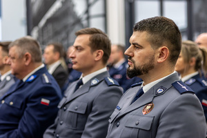 Policjanci siedzą na krzesłach.