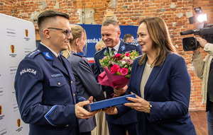 Wyróżnieni policjanci, marszałek województwa wręcza nagrody, komendant wręcza kwiaty.