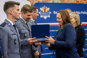 Marszałek województwa wręcza policjantom nagrodę.