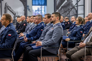 Policjanci siedzą na krzesłach.