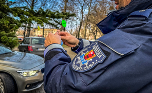 Policjant zakłada odblaski na choinkę