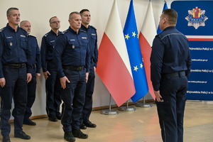 Policjant na sali składa meldunek komendantowi.