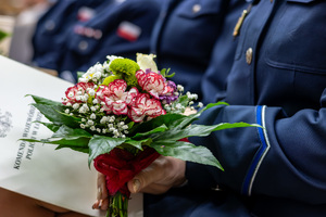 Kwiaty trzymane przez policjantkę.