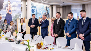 uczestnicy spotkania stoją przy stole.