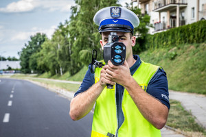 Policjant w mundurze mierzy prędkość.