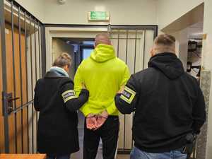 policjanci prowadzący zatrzymanego.