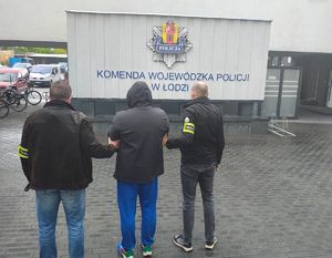 policjanci prowadzą zatrzymanego.