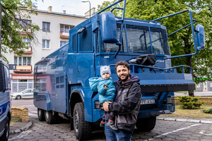 odwiedzający przed armatką wodną