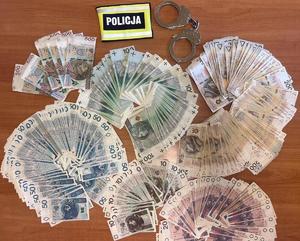 Opaska odblaskowa na atole z napisem policja, obok poukładane banknoty.