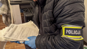 Policjant trzyma w ręku dokumentacje.