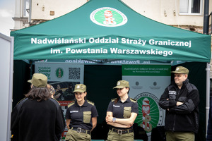 Namiot Straży Granicznej, przed nimi funkcjonariusze Straży Granicznej.